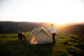 Melhores Barracas de Camping até R$2.000: Marcas e Modelos Pessoas montando uma barra no topo de uma montanha.